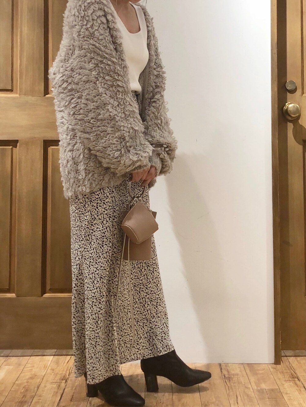 ホワイト系のスカート、ホワイト系のニット/セーター、グレー系のカーディガン/ボレロを着用したレディースの冬コーディネートの3枚目の写真