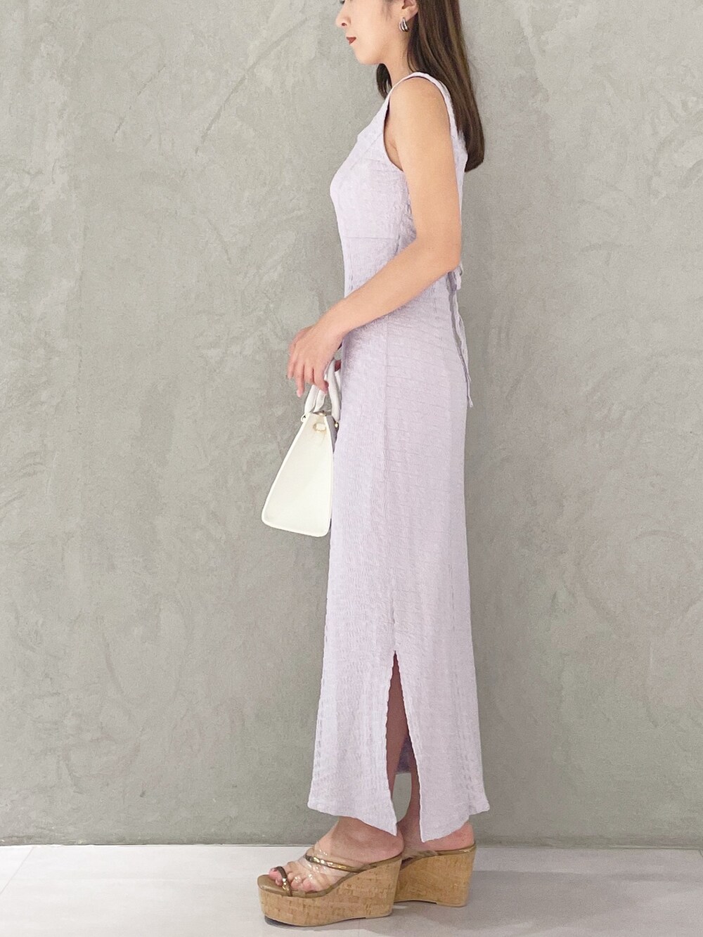 ホワイト系のショルダーバッグ、ブラウン系のサンダル、パープル系のワンピースを着用したレディースの夏コーディネートの3枚目の写真