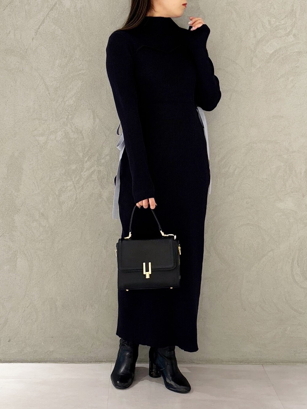 ブルー系のワンピース、ブラック系のブーツ、ブラック系のショルダーバッグを着用したレディースの冬コーディネートの4枚目の写真