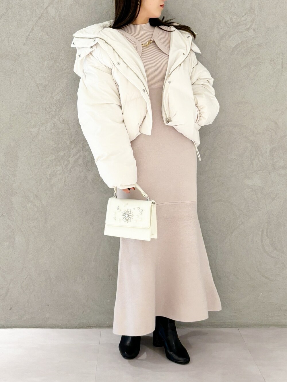 ピンク系のワンピース、ブラック系のブーツ、ホワイト系のショルダーバッグを着用したレディースの秋コーディネートの6枚目の写真