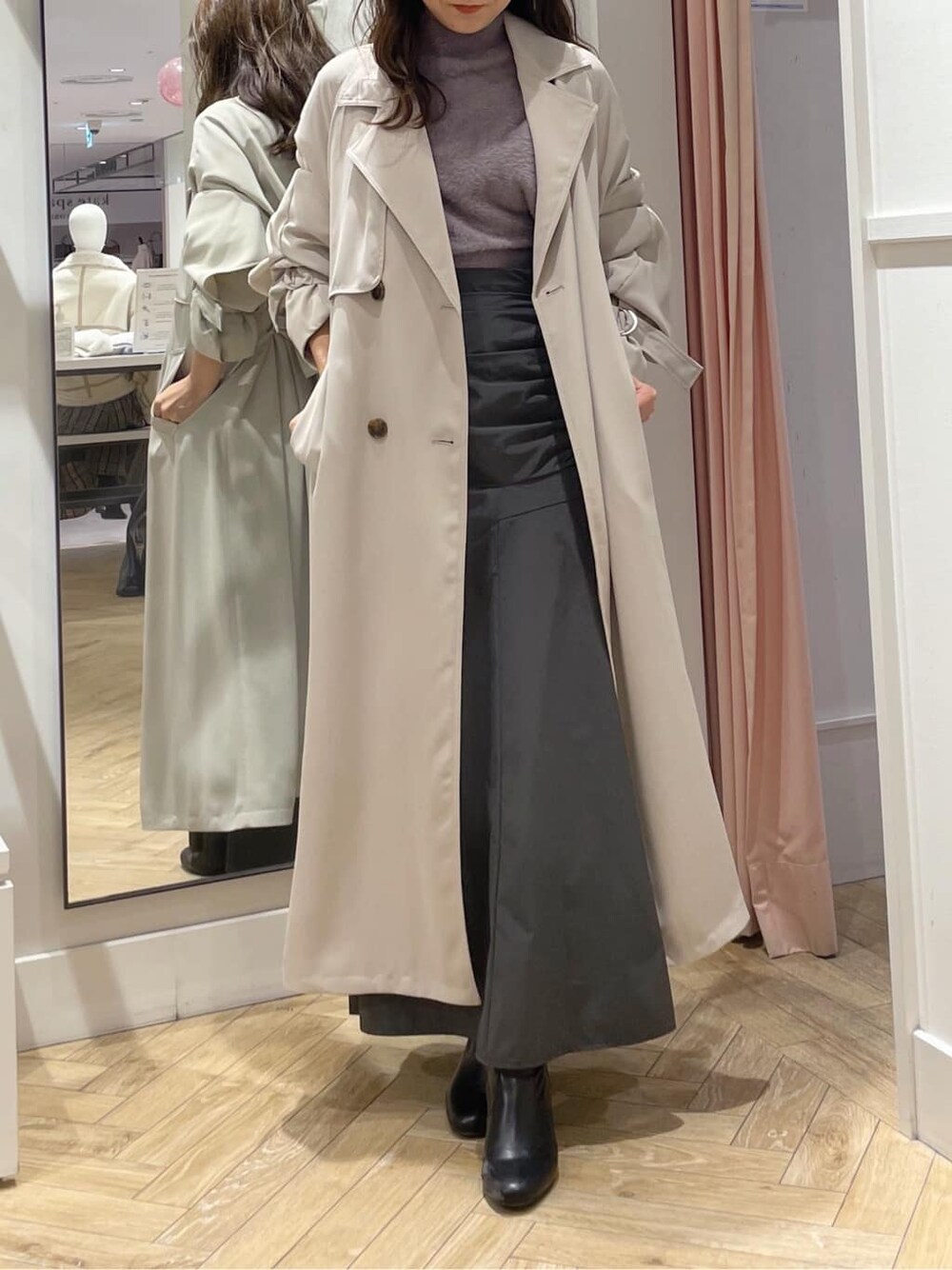 ベージュ系のトレンチコート、グレー系のスカート、グレー系のスカートを着用したレディースの秋コーディネートの4枚目の写真