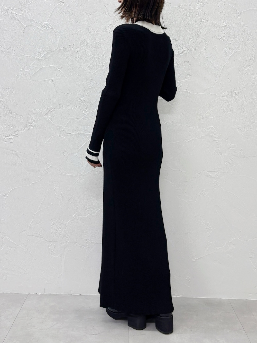 ブラック系のワンピース、ブラック系のブーツを着用したレディースの秋コーディネートの5枚目の写真