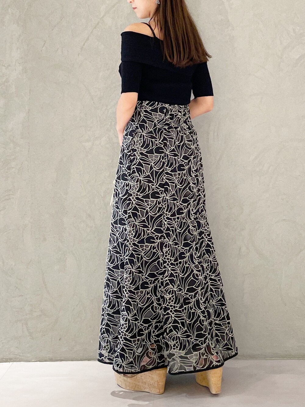 ブラック系のスカート、ブラウン系のサンダル、ベージュ系のショルダーバッグを着用したレディースの夏コーディネートの3枚目の写真