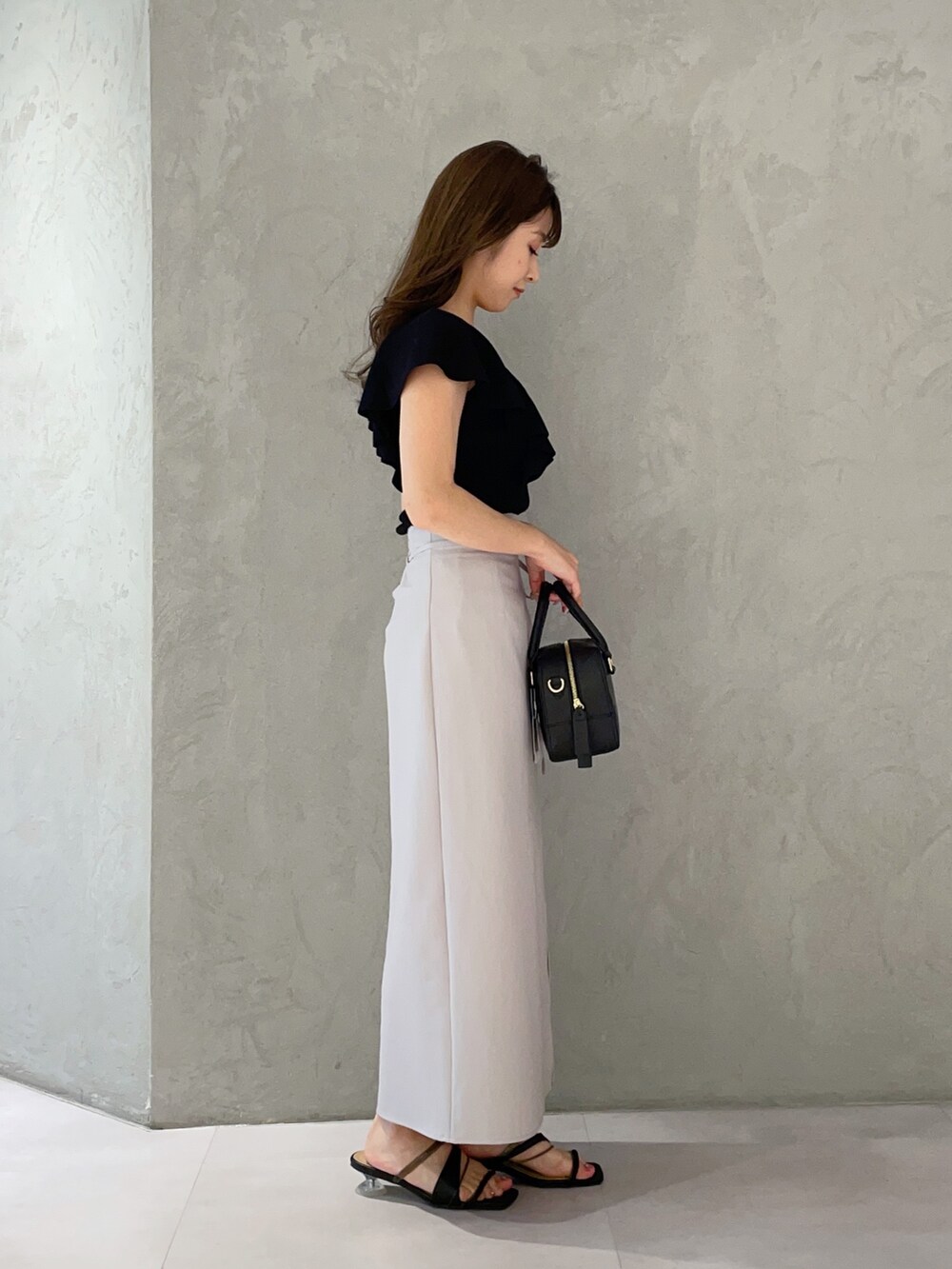 ブラック系のボストンバッグ、ブラック系のニット/セーター、ブラック系のサンダルを着用したレディースの春コーディネートの4枚目の写真