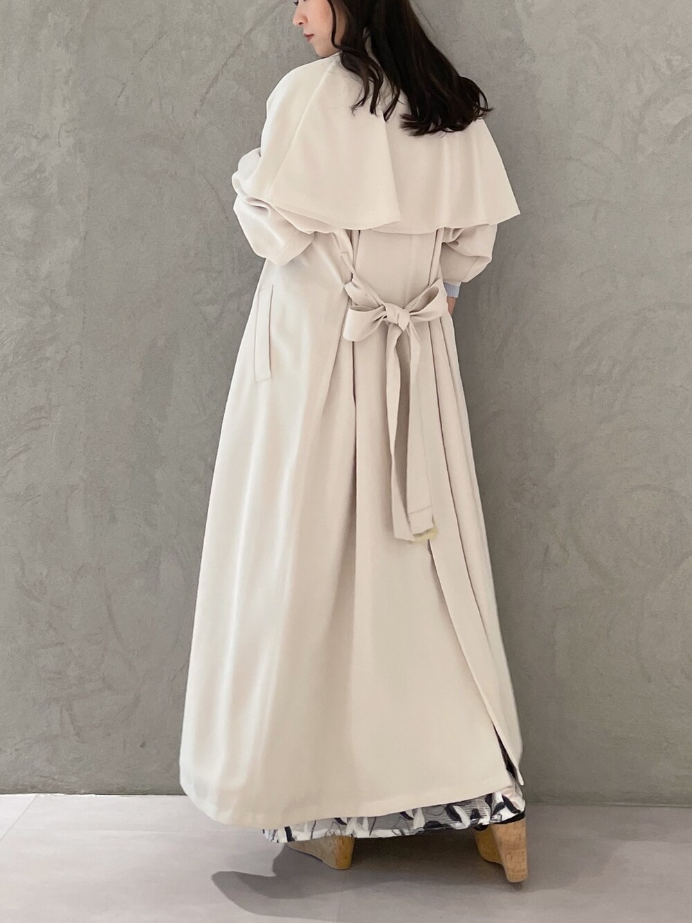 ホワイト系のスカート、ブルー系のニット/セーター、ホワイト系のトレンチコートを着用したレディースの春コーディネートの5枚目の写真