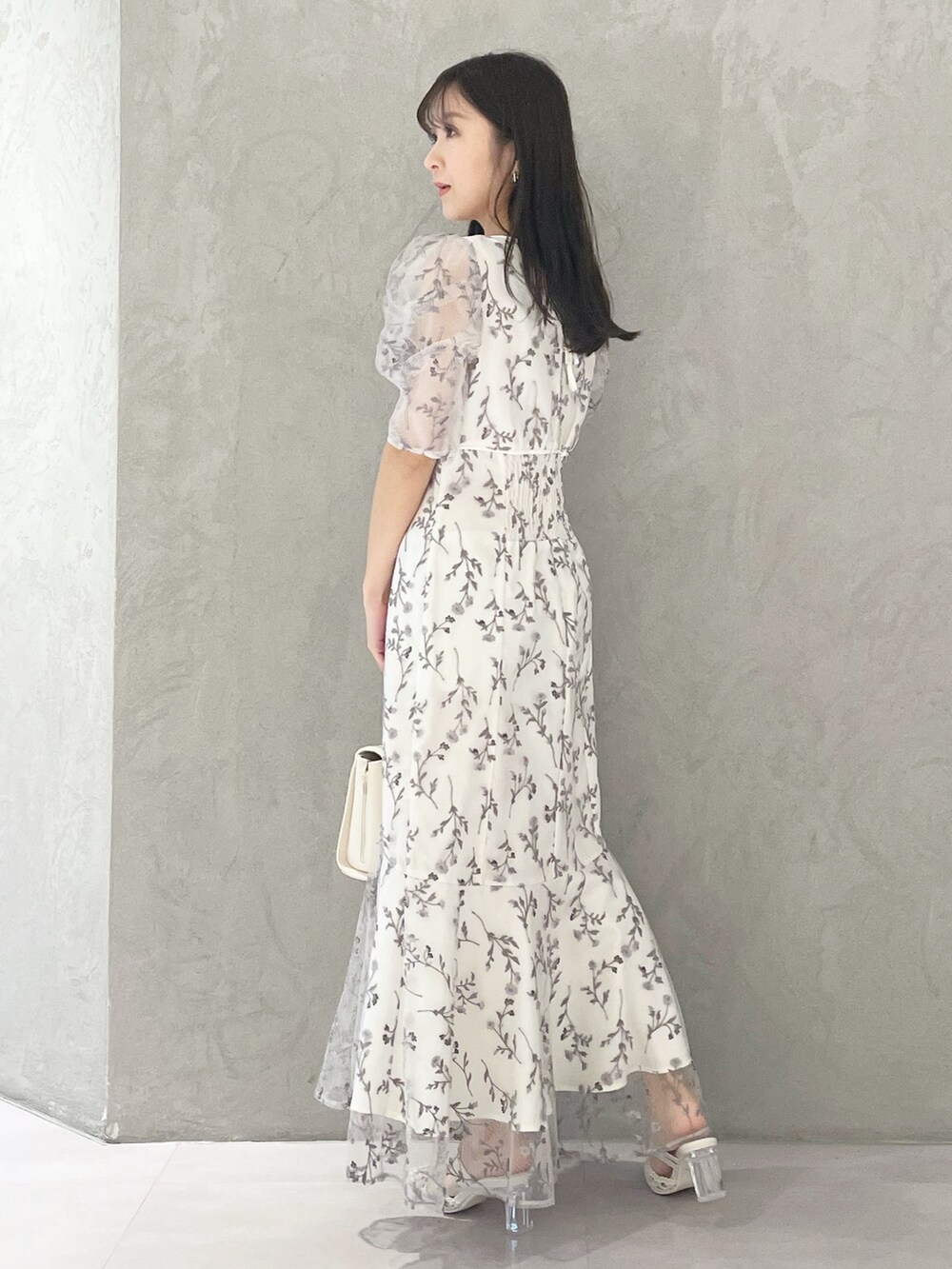 ホワイト系のショルダーバッグ、ホワイト系のパンプス、グレー系のワンピースを着用したレディースの春コーディネートの3枚目の写真