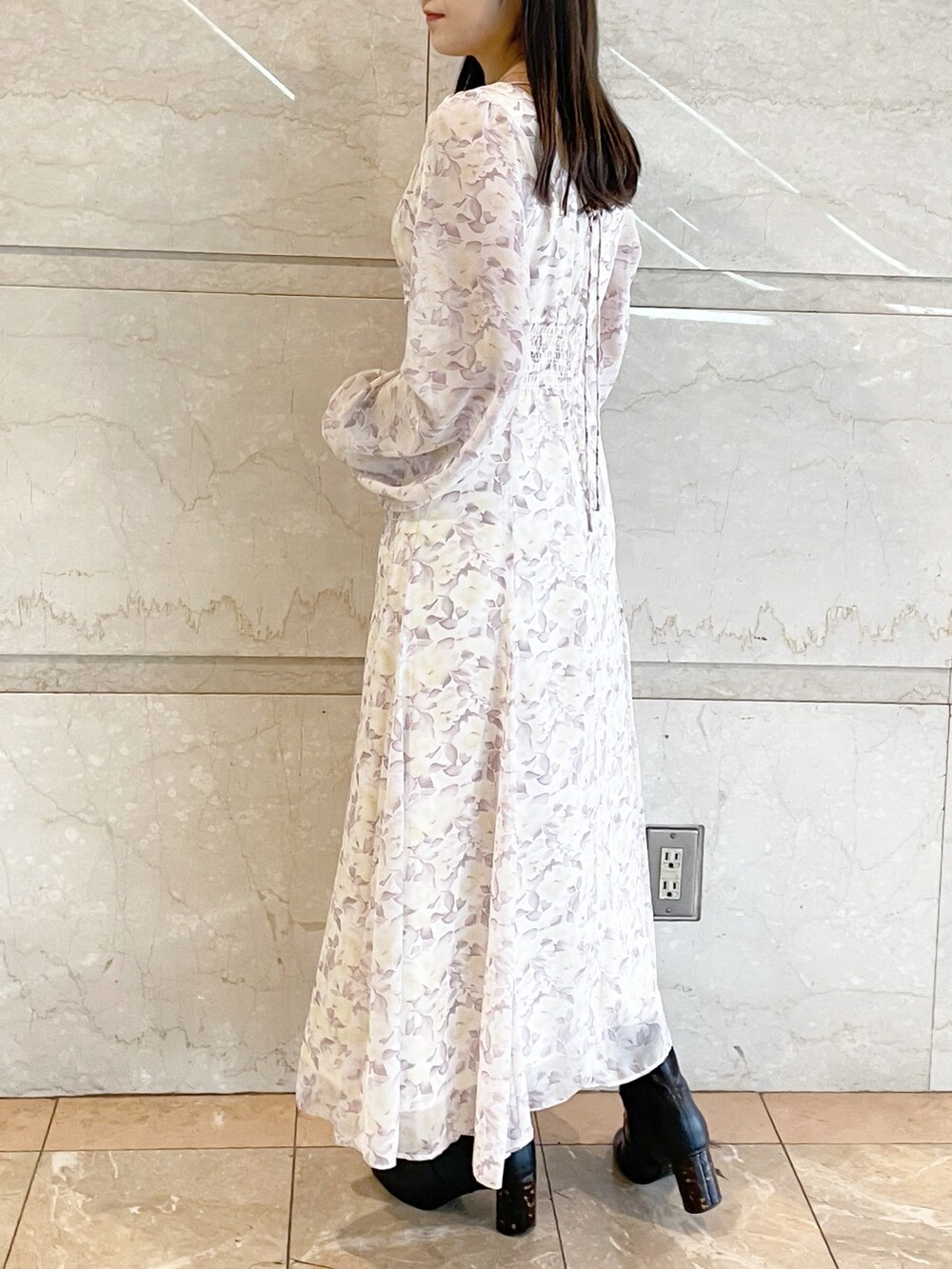 パープル系のワンピース、ブラック系のブーツを着用したレディースの冬コーディネートの3枚目の写真