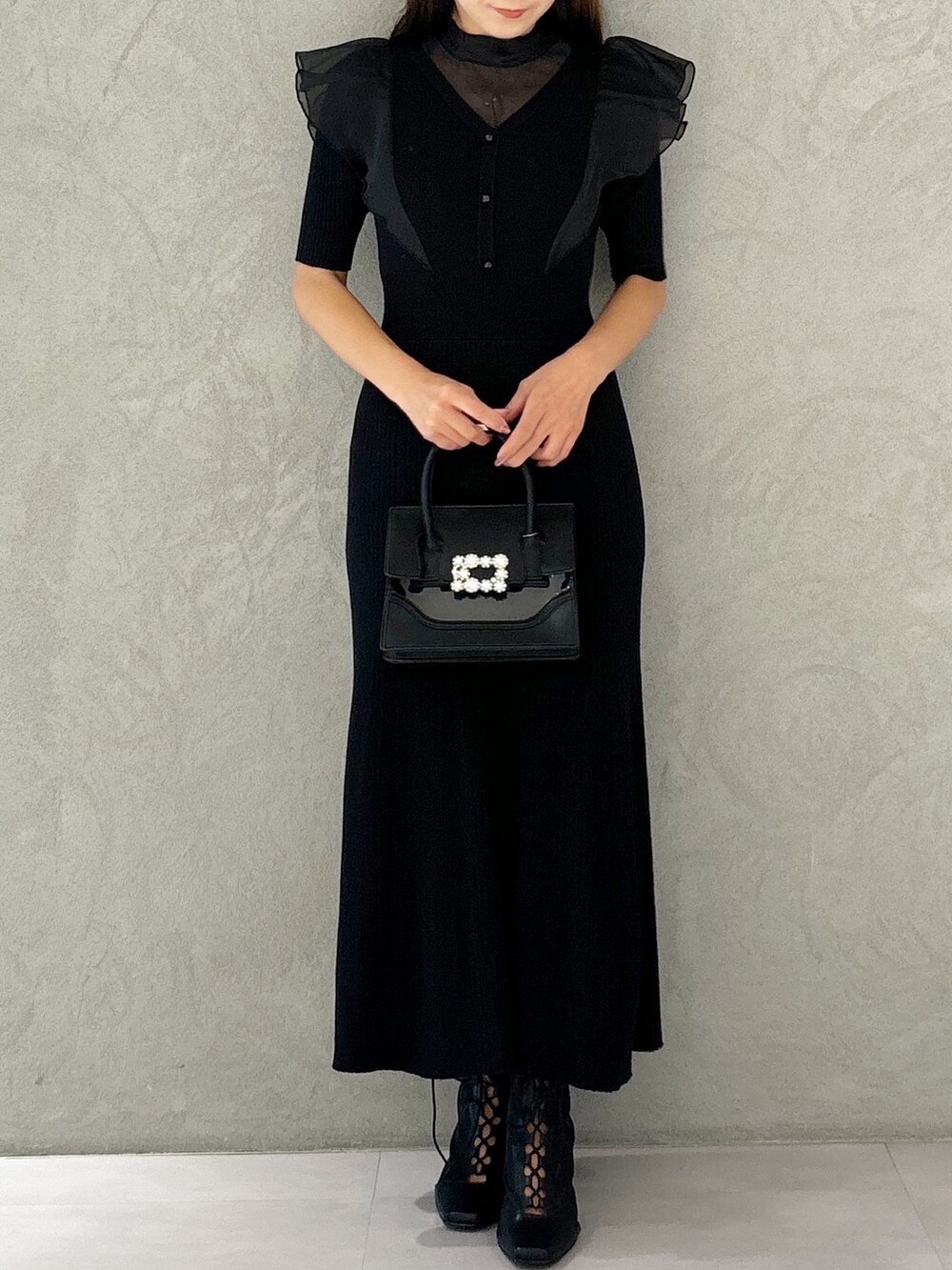 ブラック系のワンピース、ブラック系のショルダーバッグ、ブラック系のブーツを着用したレディースの夏コーディネートの6枚目の写真