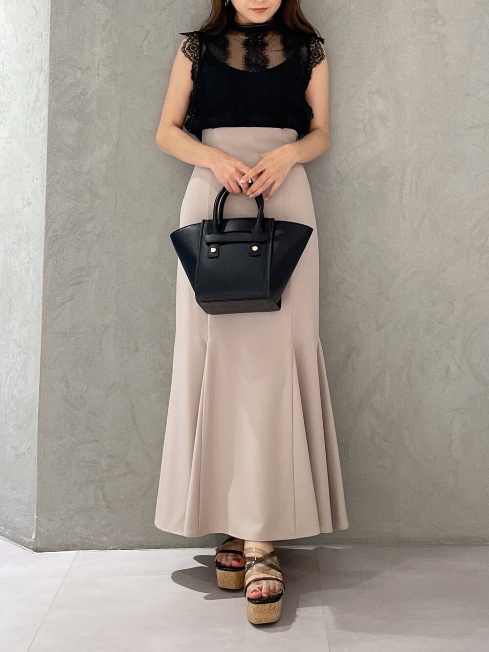 ベージュ系のスカート、ブラック系のサンダル、ブラック系のトートバッグを着用したレディースの夏コーディネートの5枚目の写真