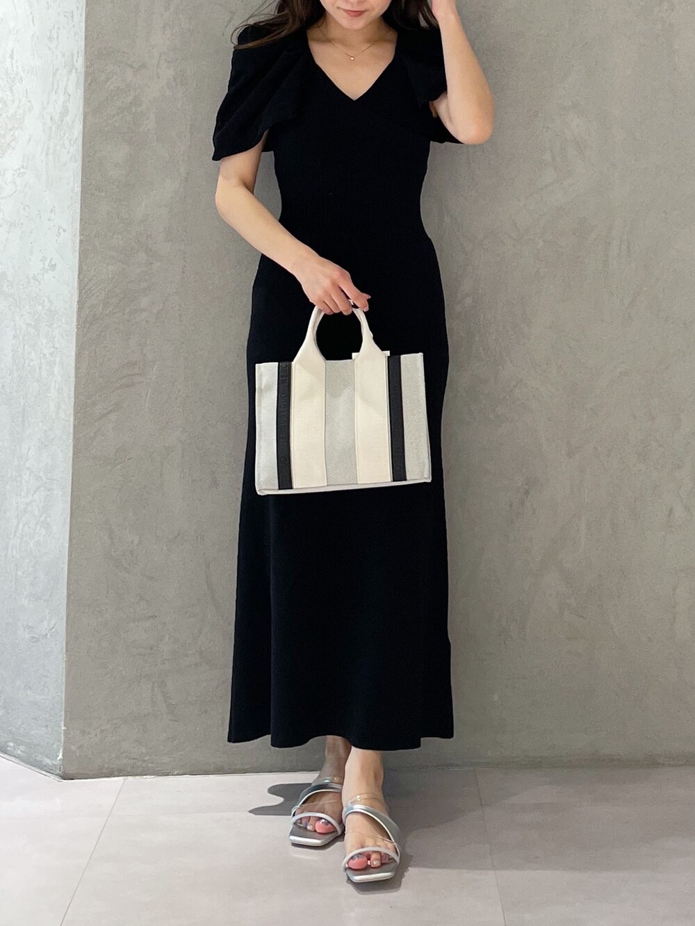 グレー系のワンピース、シルバー系のサンダル、グレー系のハンドバッグを着用したレディースの春コーディネートの8枚目の写真