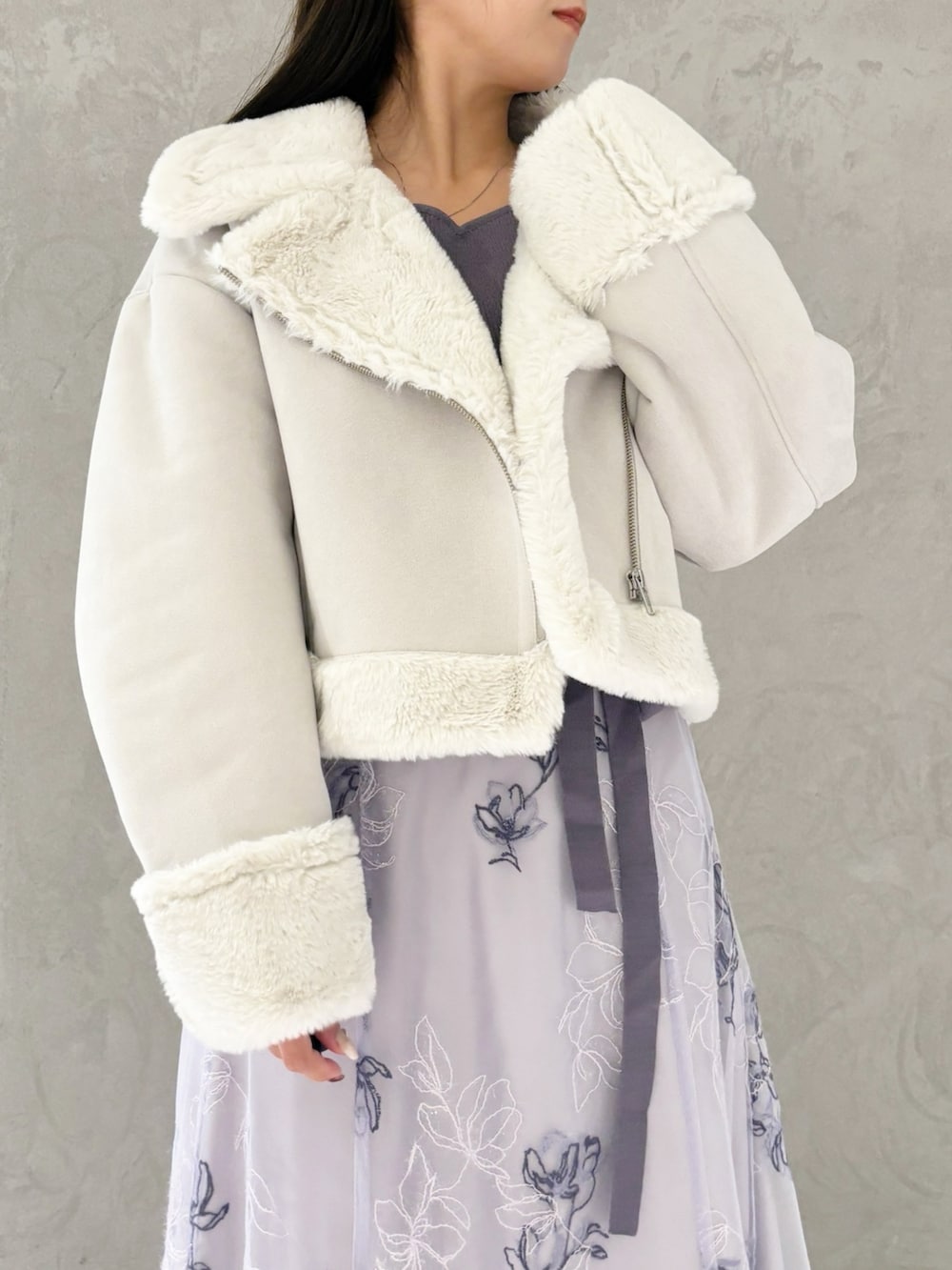 パープル系のワンピース、ブラック系のブーツ、グレー系のムートンコートを着用したレディースの秋コーディネートの2枚目の写真