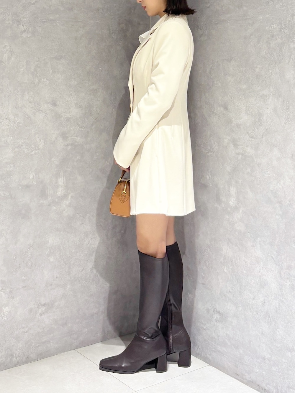 ホワイト系のワンピース、ホワイト系のシャツ/ブラウス、ブラウン系のハンドバッグを着用したレディースの春コーディネートの5枚目の写真