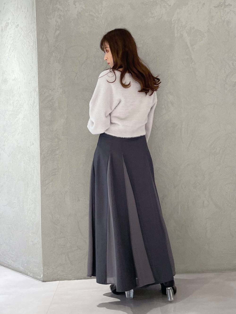 グレー系のカーディガン/ボレロ、グレー系のスカート、ブラック系のブーツを着用したレディースの冬コーディネートの6枚目の写真