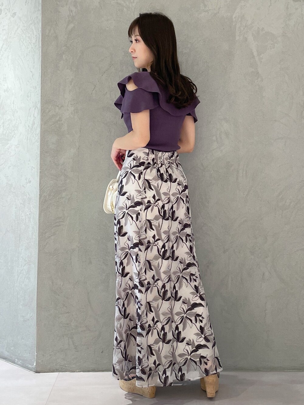 ホワイト系のハンドバッグ、ブラック系のサンダル、パープル系のニット/セーターを着用したレディースの春コーディネートの8枚目の写真