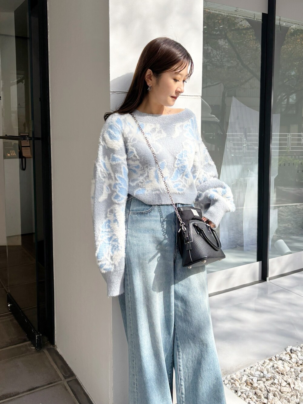 ブルー系のデニムパンツ、ブラック系のブーツ、ブルー系のニット/セーターを着用したレディースの冬コーディネートの6枚目の写真