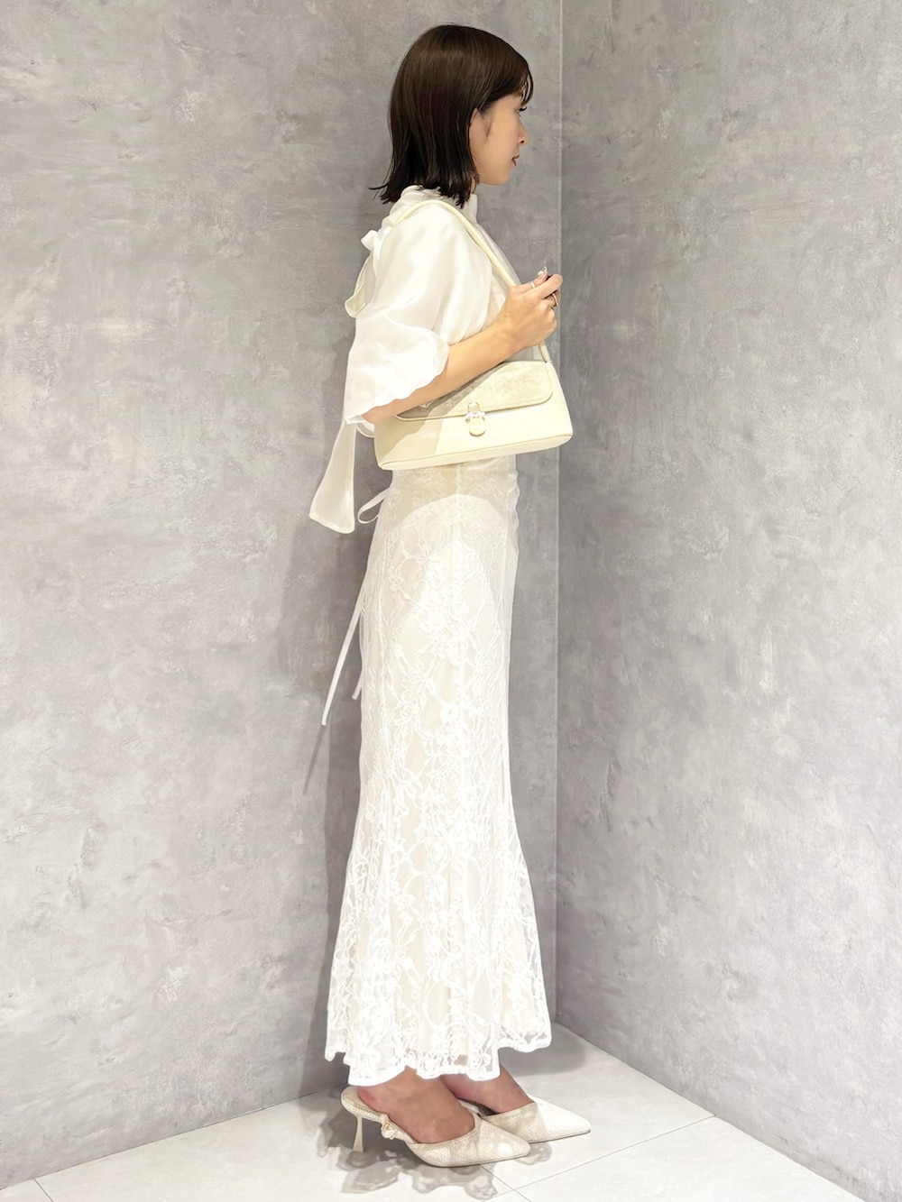 ホワイト系のスカート、ホワイト系のシャツ/ブラウス、ホワイト系のハンドバッグを着用したレディースの春コーディネートの2枚目の写真