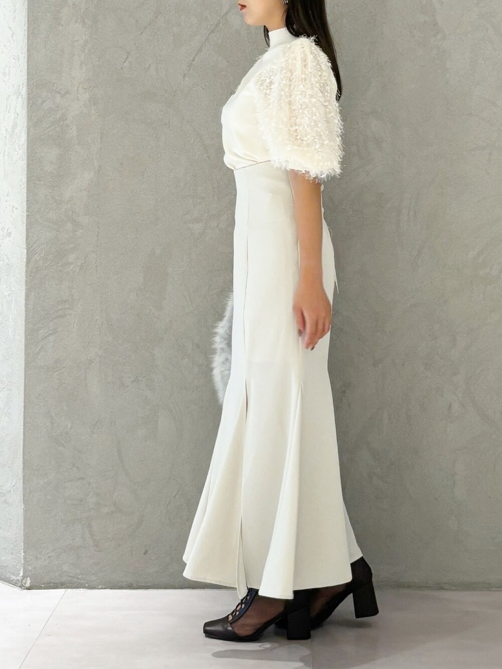 ブラウン系のブーツ、グレー系のハンドバッグ、ホワイト系のスカートを着用したレディースの夏コーディネートの3枚目の写真