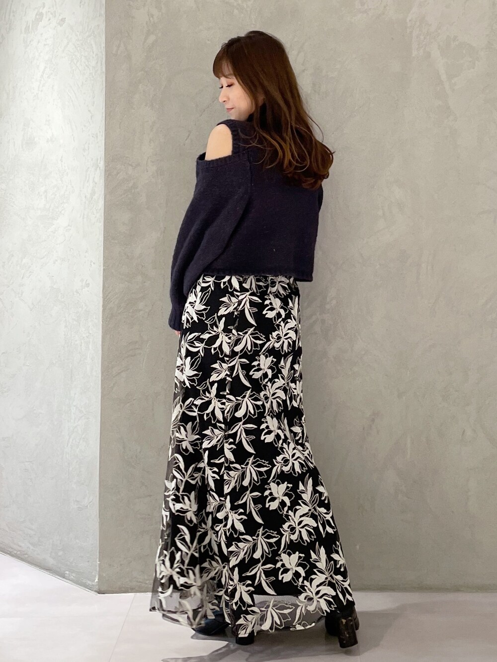 ブルー系のスカート、グレー系のニット/セーターを着用したレディースの秋コーディネートの5枚目の写真