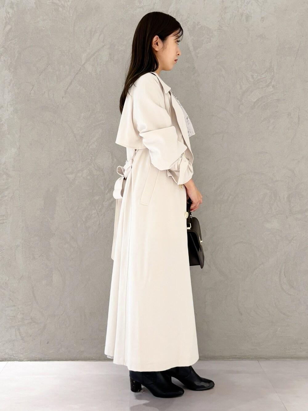 ピンク系のワンピース、ブラック系のブーツ、ブラウン系のハンドバッグを着用したレディースの春コーディネートの3枚目の写真