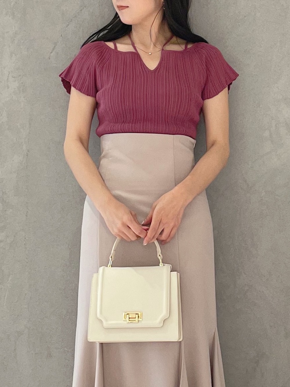 ブラック系のサンダル、ホワイト系のハンドバッグ、ピンク系のスカートを着用したレディースの春コーディネートの3枚目の写真