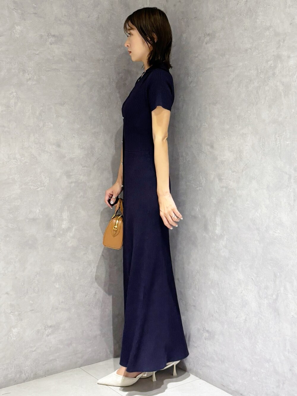 ブラウン系のハンドバッグ、ホワイト系のパンプス、ブルー系のワンピースを着用したレディースの春コーディネートの5枚目の写真