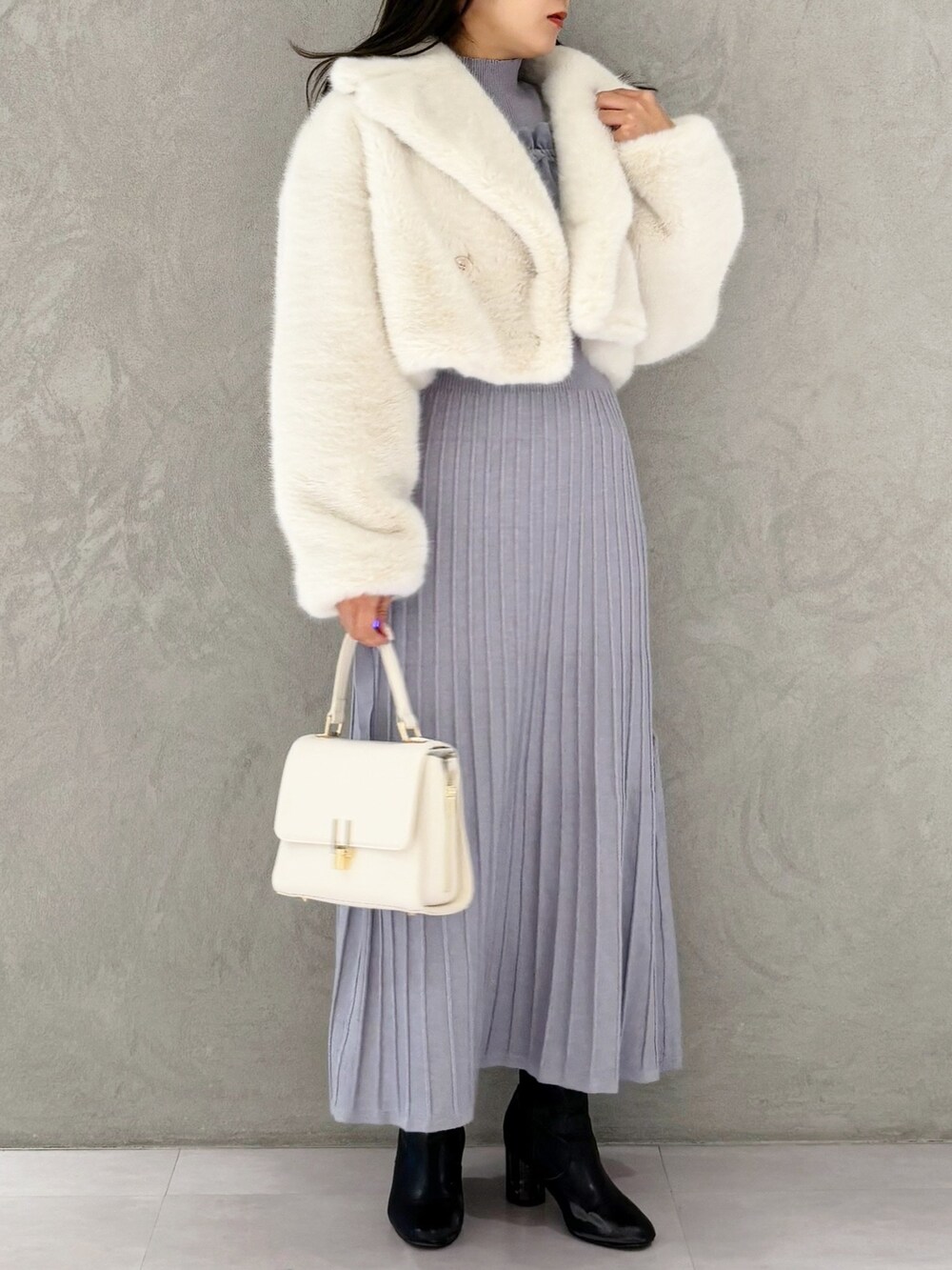 ブルー系のワンピース、ブラック系のブーツ、ホワイト系のその他アウターを着用したレディースの冬コーディネートの8枚目の写真