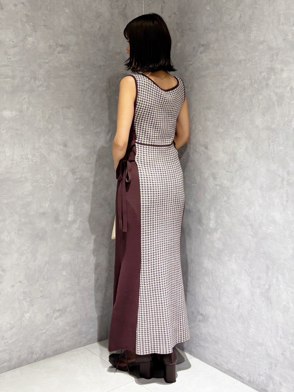 ブラウン系のワンピース、ブラウン系のブーツ、ホワイト系のハンドバッグを着用したレディースの夏コーディネートの5枚目の写真