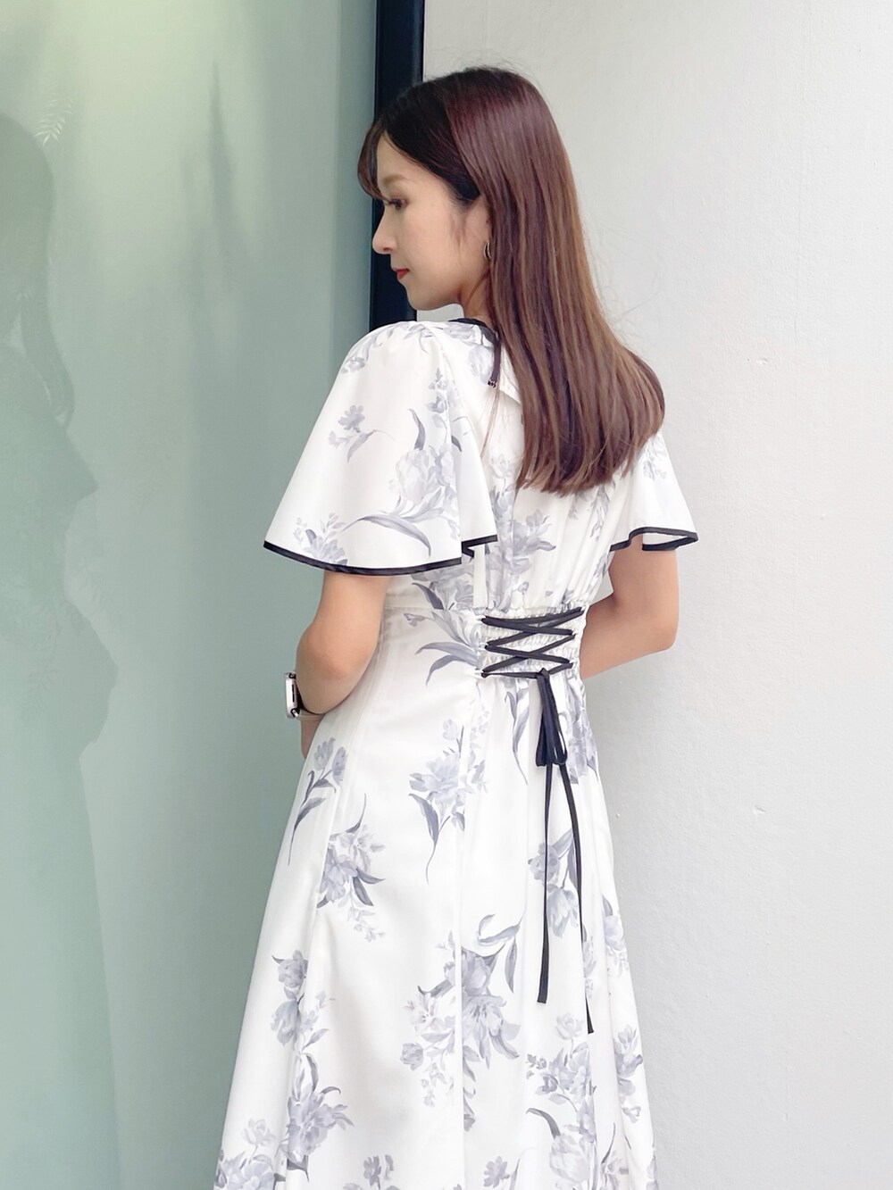 ブラック系のサンダル、ホワイト系のワンピースを着用したレディースの夏コーディネートの3枚目の写真