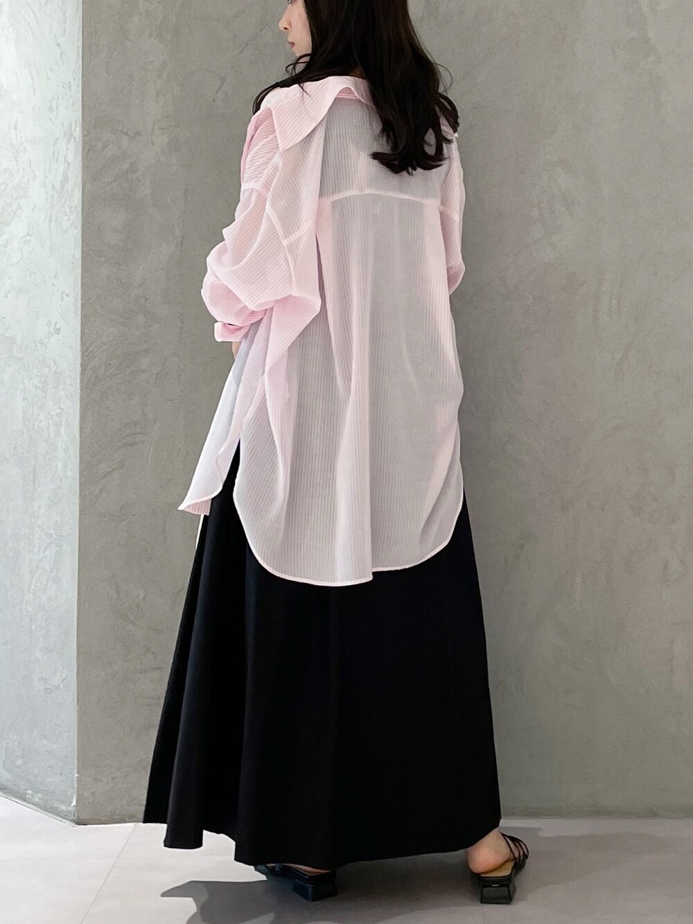 ブラック系のワンピース、ブラック系のサンダル、ホワイト系のハンドバッグを着用したレディースの春コーディネートの5枚目の写真