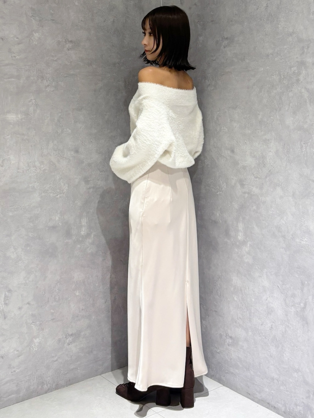 ピンク系のスカート、ホワイト系のニット/セーター、ブラウン系のブーツを着用したレディースの秋コーディネートの4枚目の写真