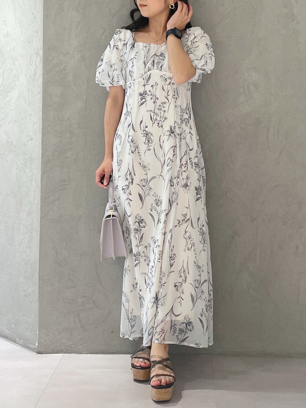 ホワイト系のワンピース、パープル系のハンドバッグ、ブラック系のサンダルを着用したレディースの春コーディネートの7枚目の写真