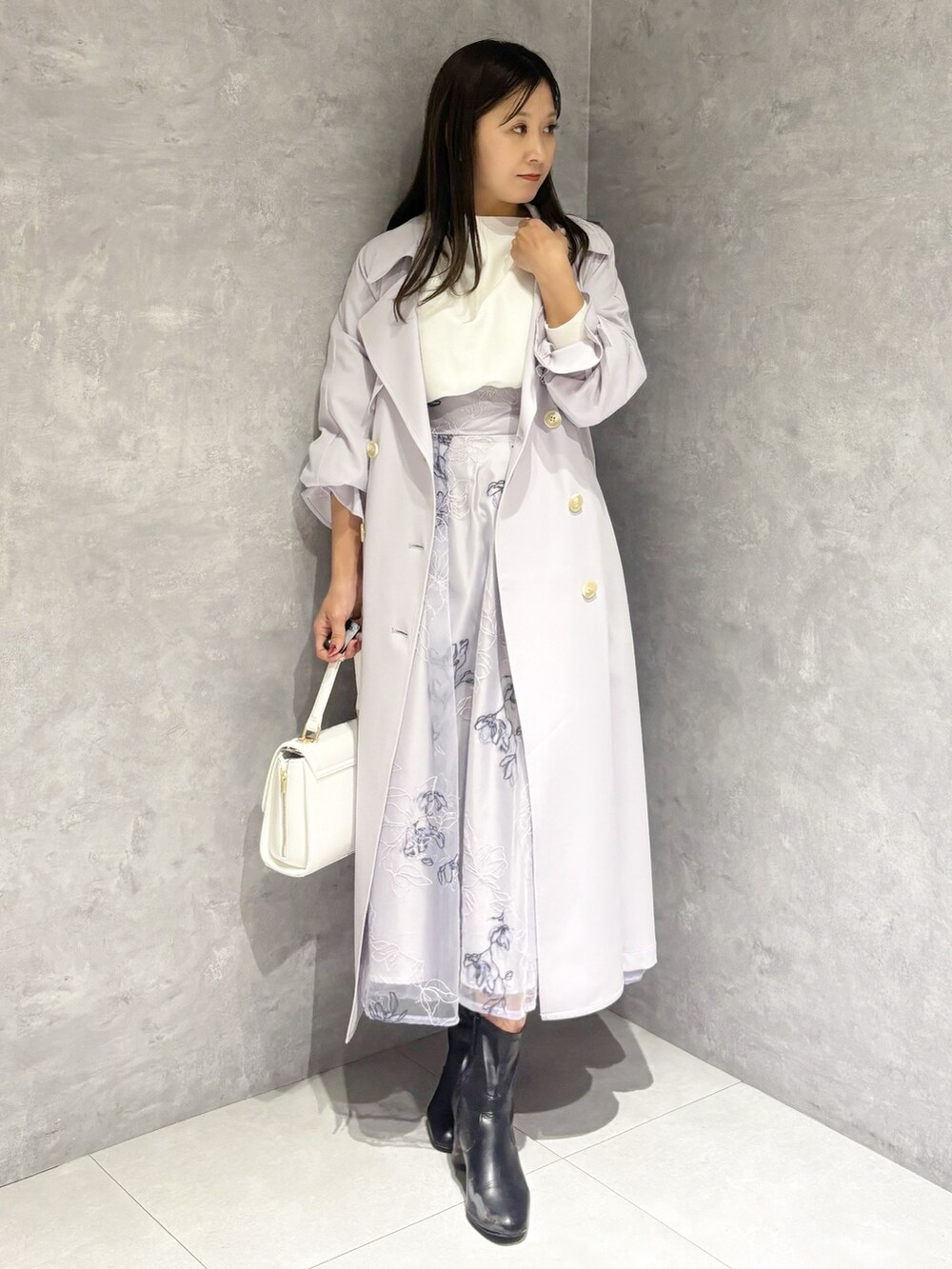 パープル系のスカート、ブラック系のブーツ、ホワイト系のハンドバッグを着用したレディースの冬コーディネートの6枚目の写真