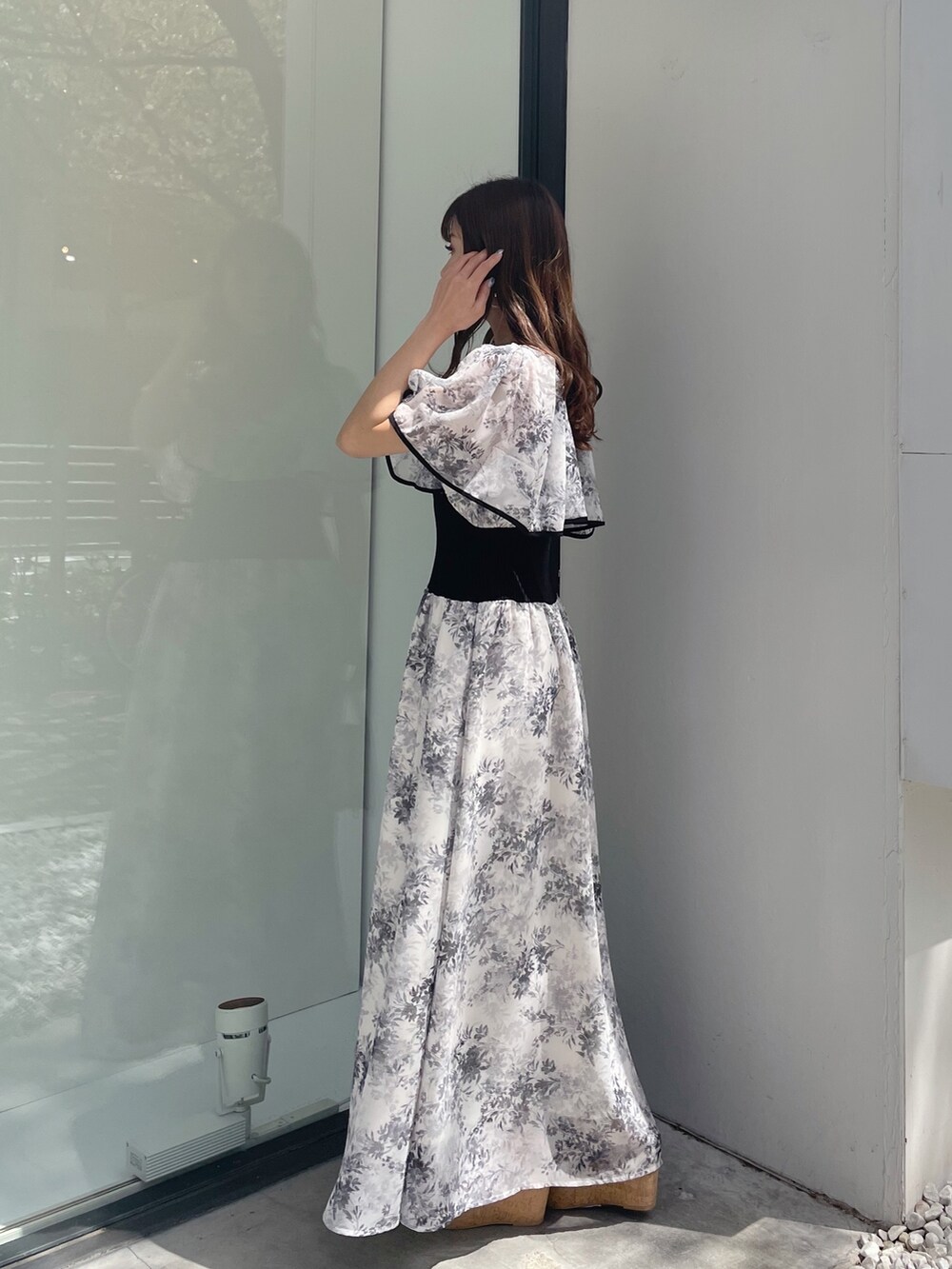 ブラック系のサンダル、ホワイト系のハンドバッグ、ホワイト系のワンピースを着用したレディースの春コーディネートの8枚目の写真