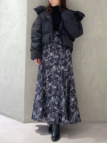 ブラック系のダウンジャケット/コート、ブラック系のニット/セーター、ブルー系のスカートを着用したレディースの秋コーディネートの5枚目の写真