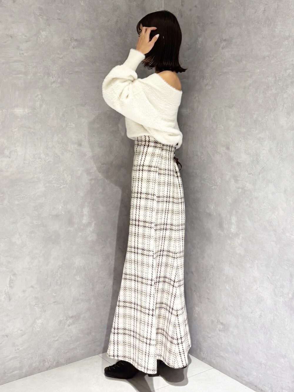 ホワイト系のスカート、ホワイト系のニット/セーター、ブラウン系のブーツを着用したレディースの秋コーディネートの6枚目の写真