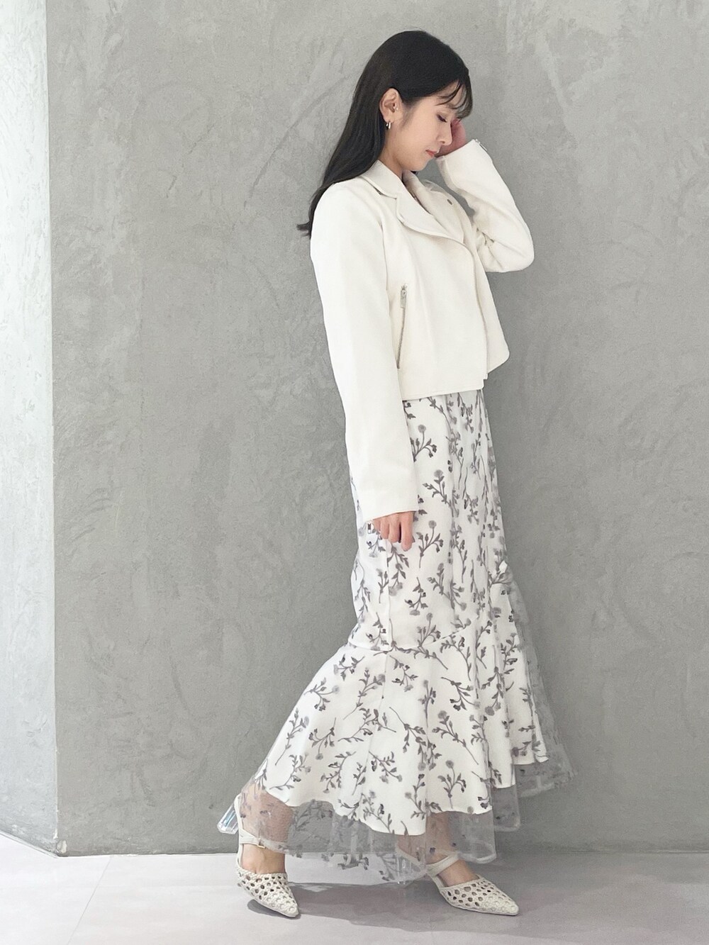 グレー系のワンピース、ホワイト系のパンプス、ホワイト系のライダースジャケットを着用したレディースの春コーディネートの4枚目の写真