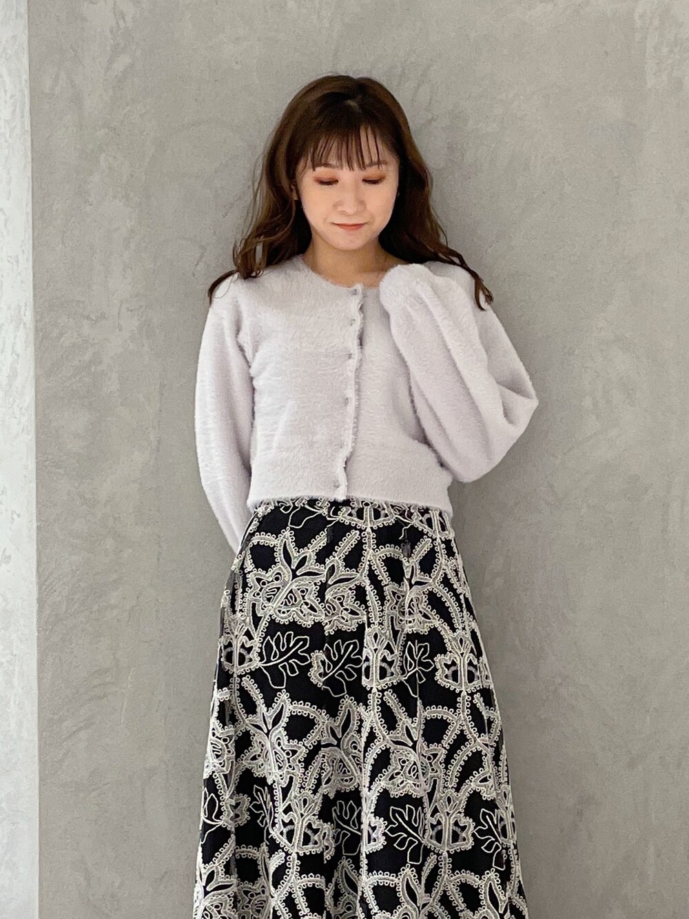 ブラック系のスカート、グレー系のカーディガン/ボレロ、ブラック系のブーツを着用したレディースの冬コーディネートの6枚目の写真