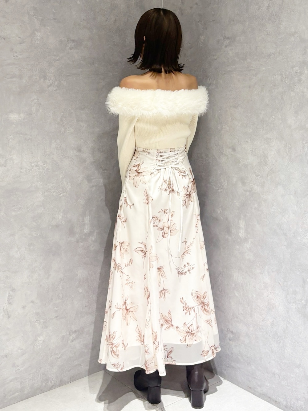 ホワイト系のワンピース、ブラウン系のブーツ、ブラック系のハンドバッグを着用したレディースの冬コーディネートの3枚目の写真