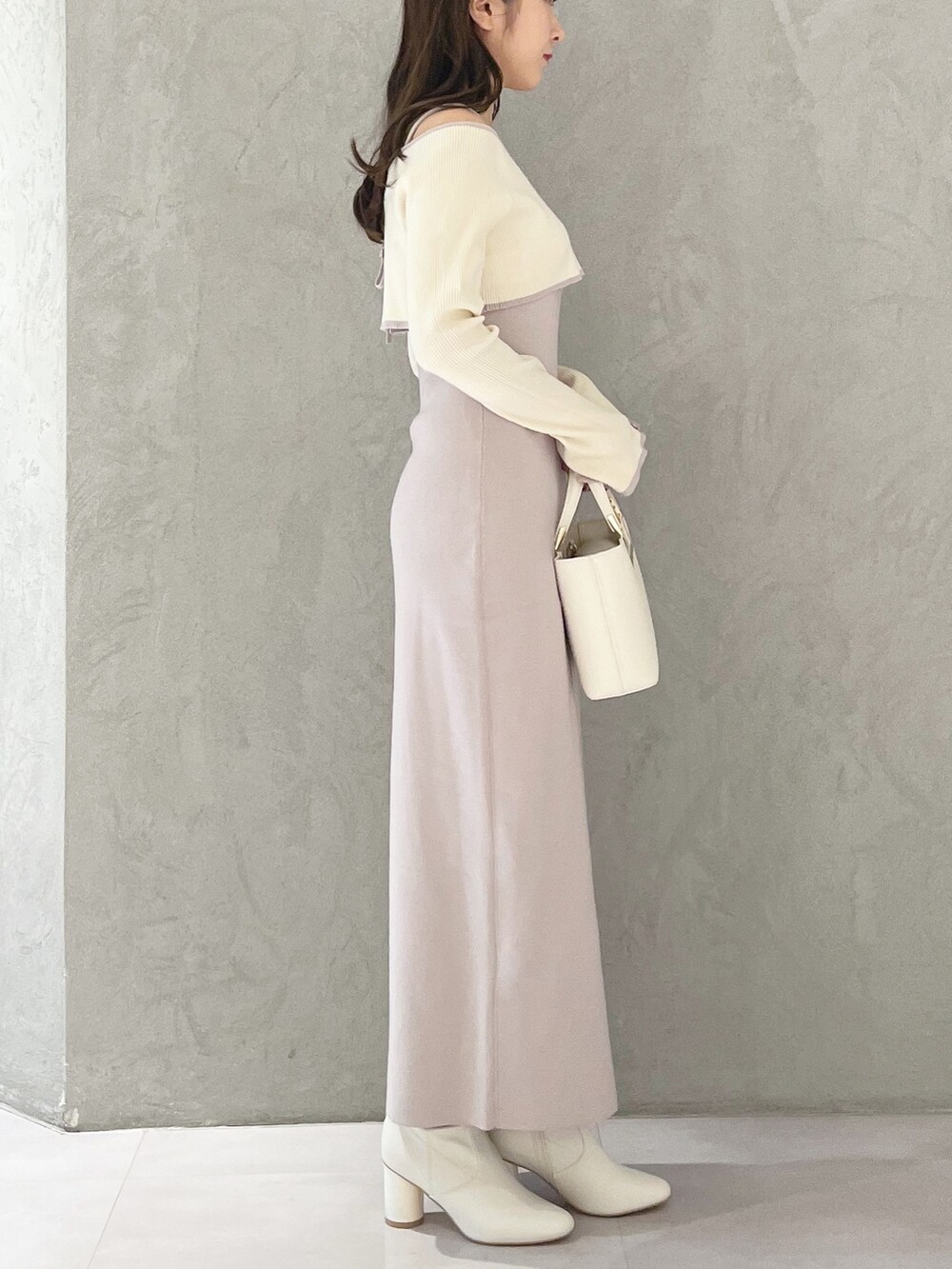 ピンク系のワンピース、ホワイト系のハンドバッグ、ホワイト系のブーツを着用したレディースの秋コーディネートの4枚目の写真