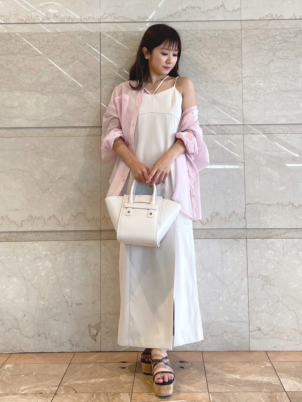 ホワイト系のトートバッグ、ブラック系のサンダル、ベージュ系のワンピースを着用したレディースの夏コーディネートの7枚目の写真