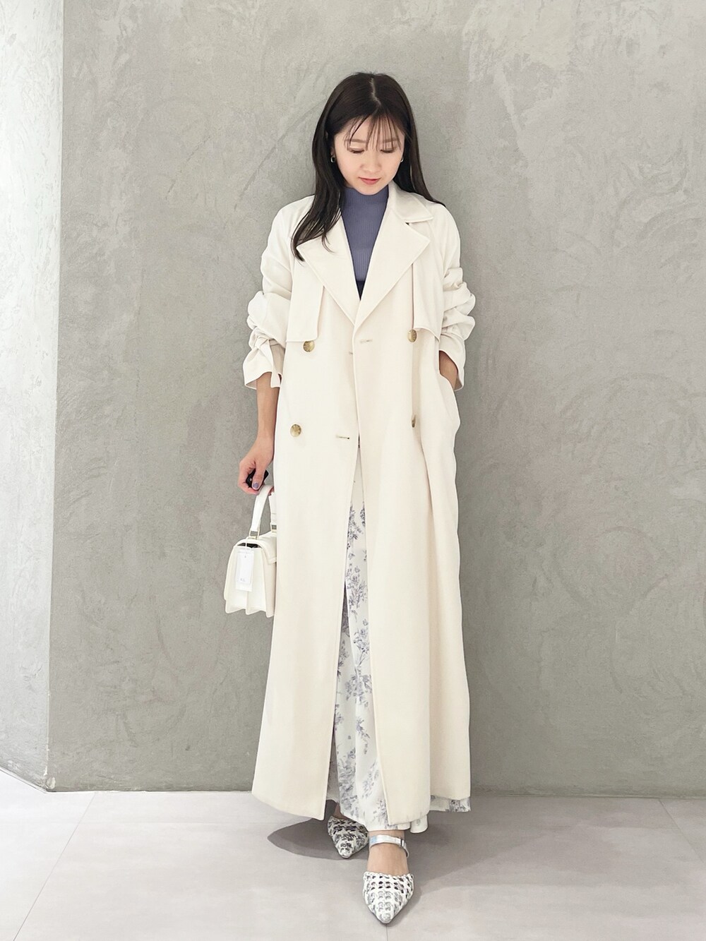 シルバー系のパンプス、ホワイト系のショルダーバッグ、ブルー系のニット/セーターを着用したレディースの春コーディネートの5枚目の写真