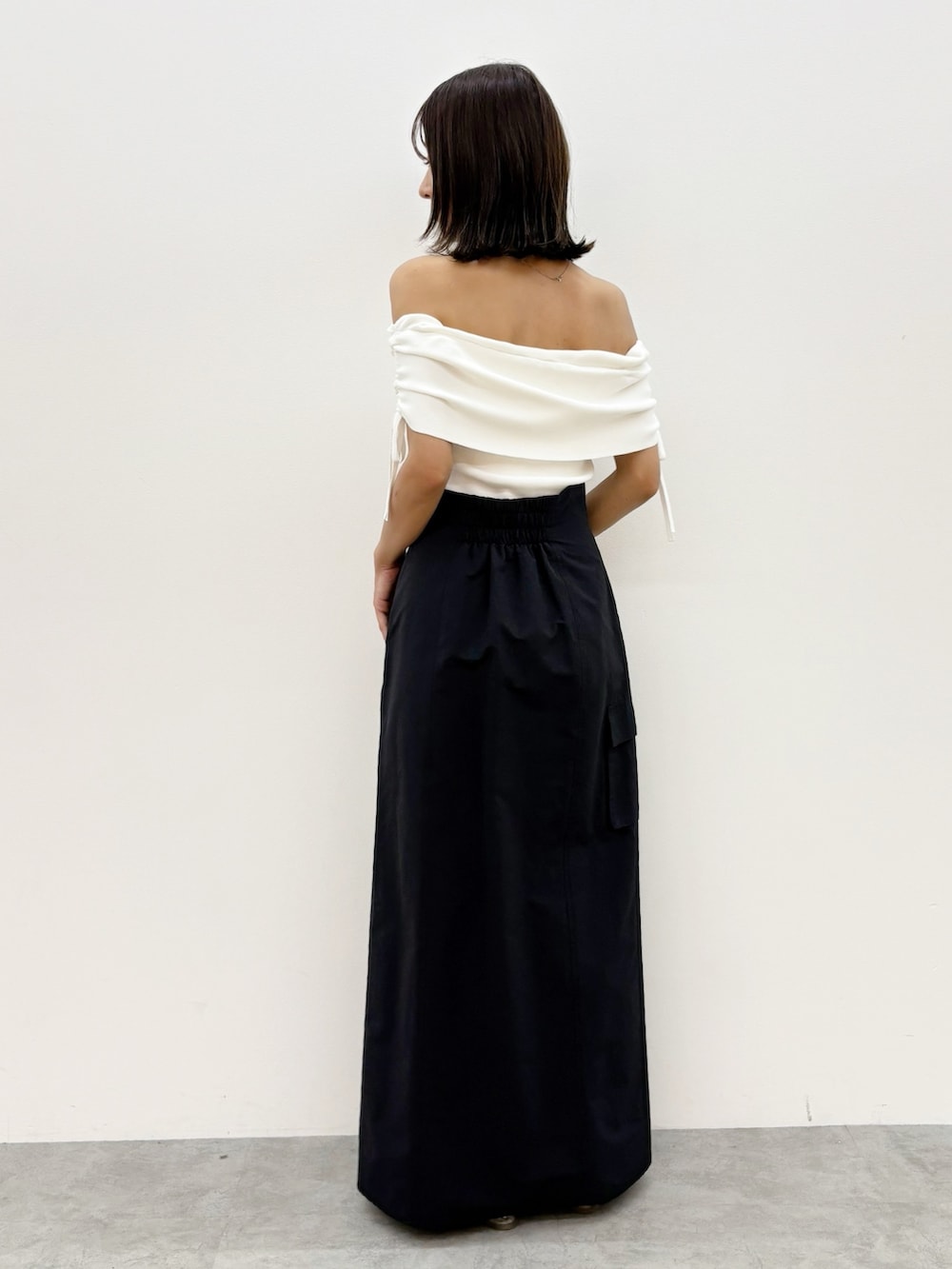 ブラック系のスカート、ホワイト系のニット/セーターを着用したレディースの夏コーディネートの5枚目の写真