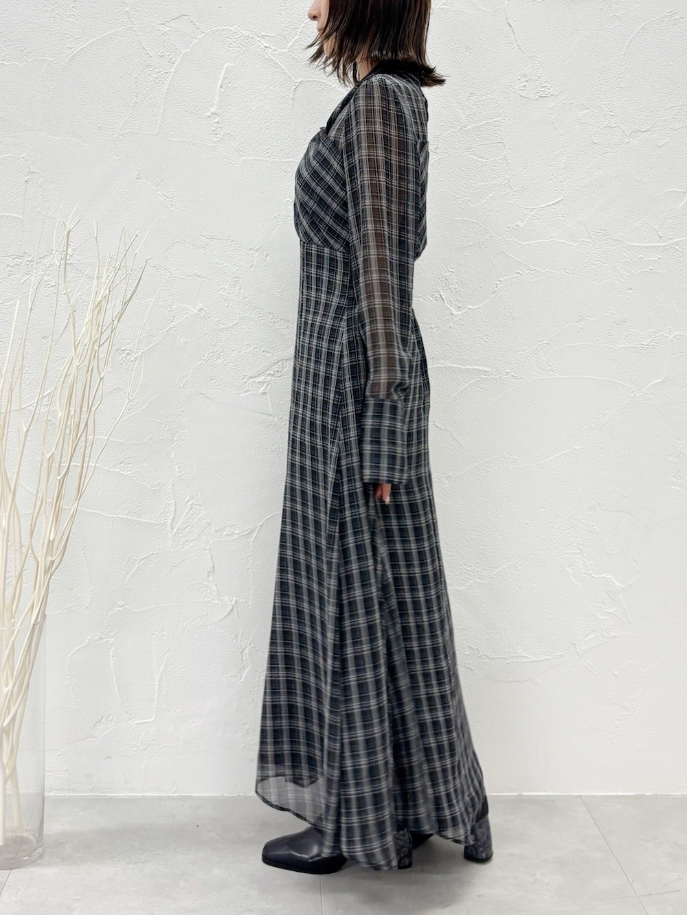 ブラック系のワンピース、ブラック系のブーツを着用したレディースの秋コーディネートの3枚目の写真