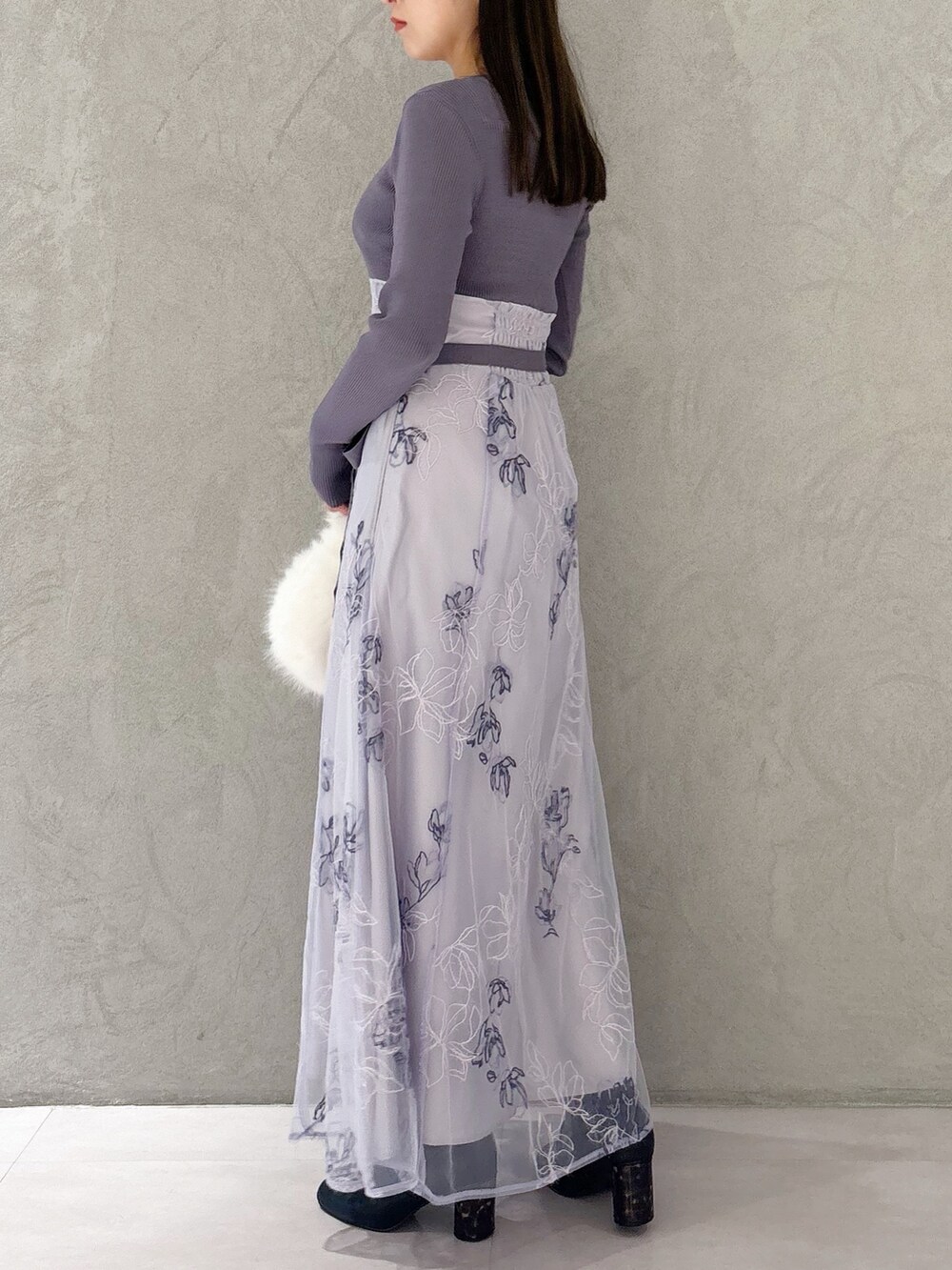 パープル系のワンピース、ブラック系のブーツ、ホワイト系のハンドバッグを着用したレディースの秋コーディネートの6枚目の写真