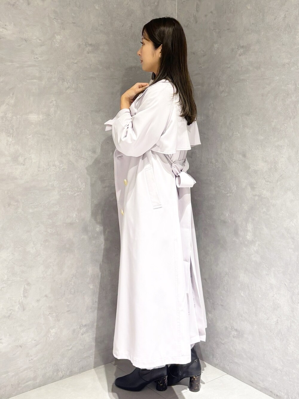 パープル系のスカート、ブラック系のブーツ、ホワイト系のハンドバッグを着用したレディースの冬コーディネートの3枚目の写真