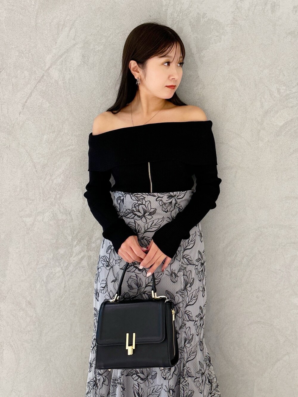 グレー系のスカート、ブラック系のブーツ、ブラック系のショルダーバッグを着用したレディースの秋コーディネートの7枚目の写真