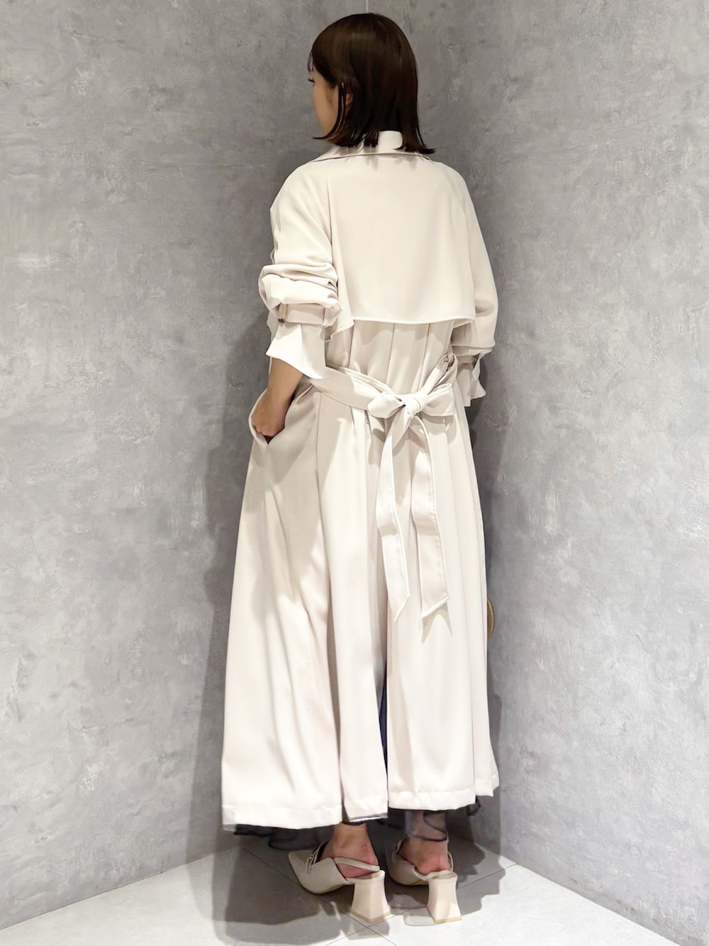 ブルー系のスカート、ホワイト系のニット/セーター、ホワイト系のパンプスを着用したレディースの春コーディネートの5枚目の写真