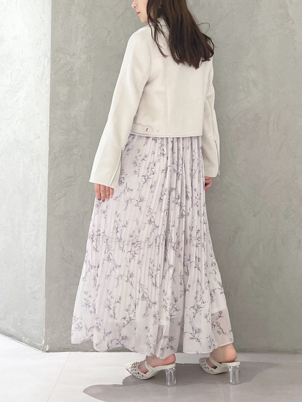 ピンク系のワンピース、ホワイト系のパンプス、ホワイト系のライダースジャケットを着用したレディースの春コーディネートの3枚目の写真