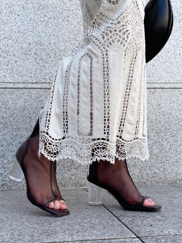 ホワイト系のスカート、ゴールド系のハンドバッグ、ブラック系のその他シューズを着用したレディースの夏コーディネートの6枚目の写真