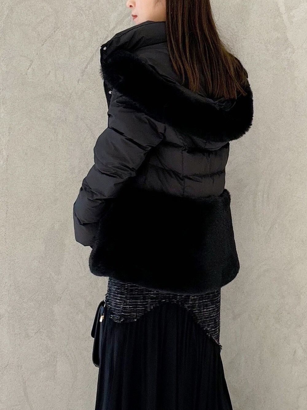 ブラック系のスカート、ブラック系のブーツ、ブラック系のショルダーバッグを着用したレディースの秋コーディネートの5枚目の写真